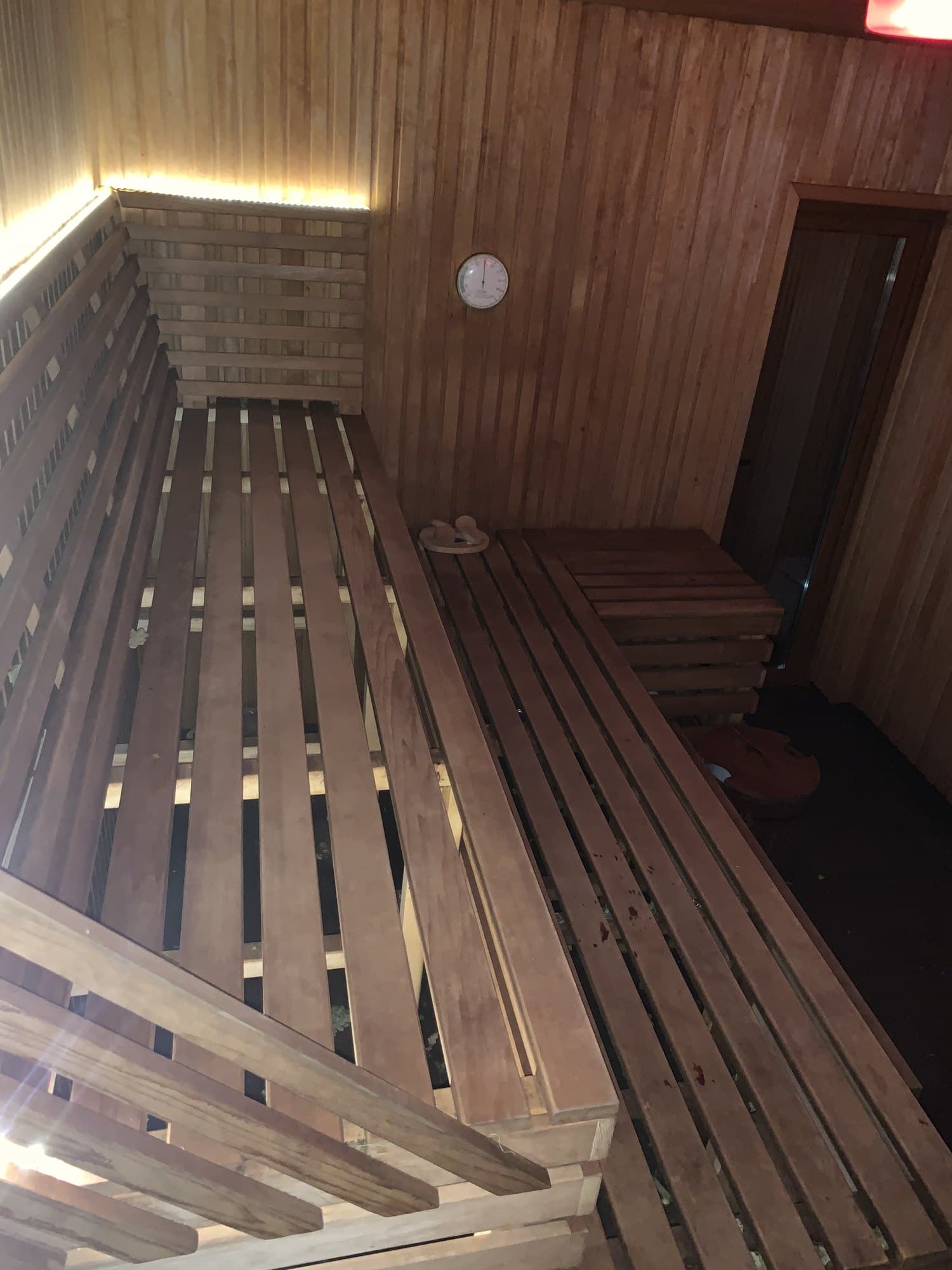 Pirts iekšpuse vakarā, silta LED gaisma zem augšējā lāviņa